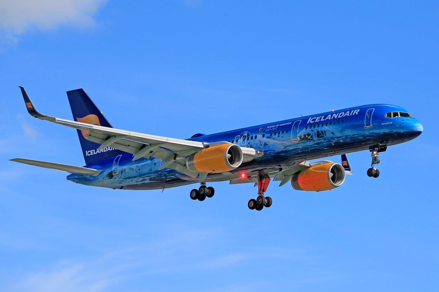 Un avion d'Icelandair en livrée spéciale bleue sur un ciel dégagé