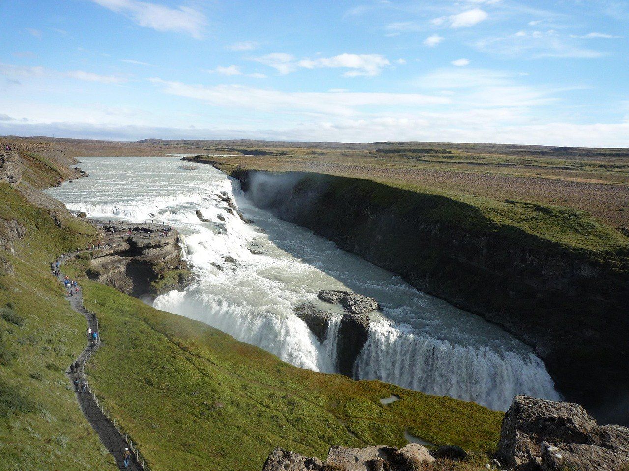 La cascade de Gullfoss plongeant dans son canyon, avec le sentier de randonnée le long du rebord