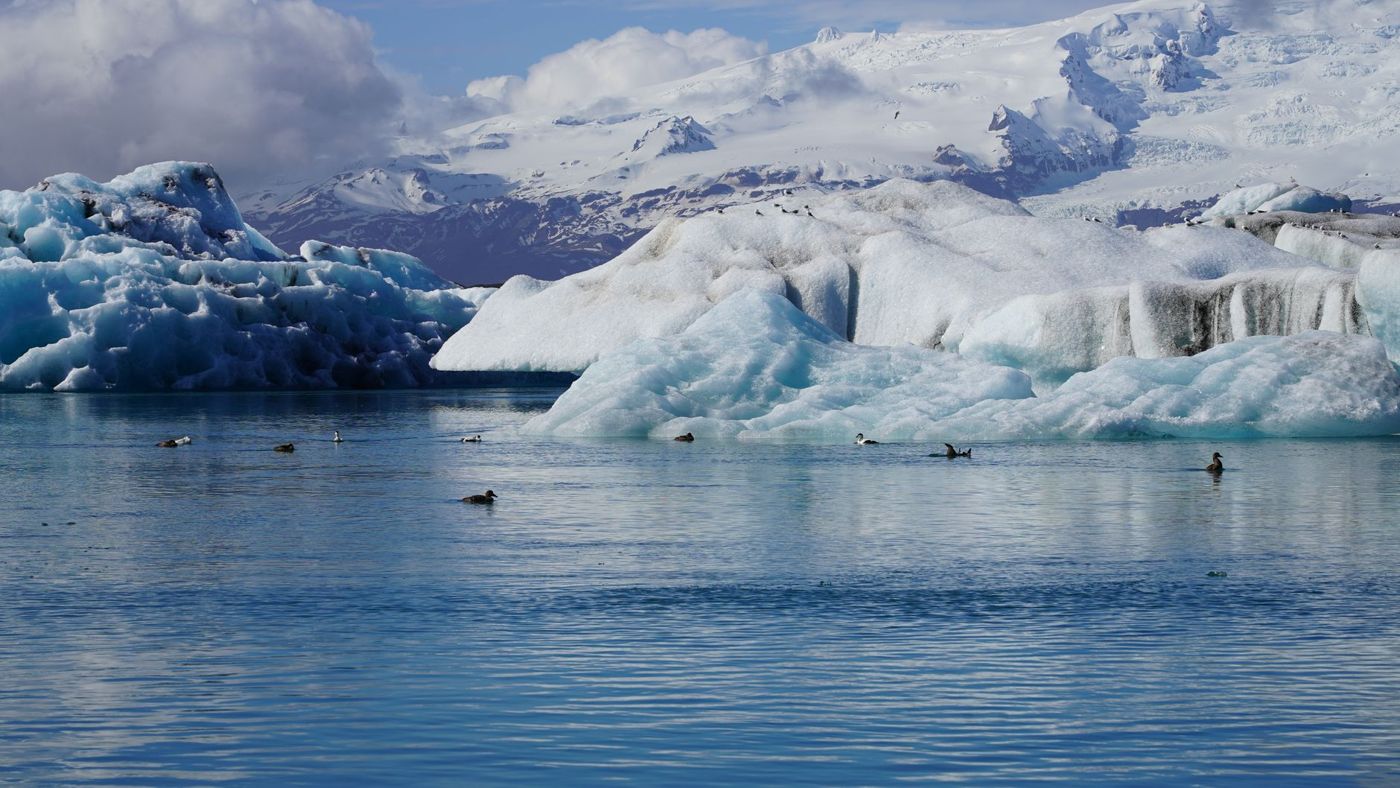 Icebergs floating in Jökulsárlón glacier lagoon with Diamond Beach in the distance
