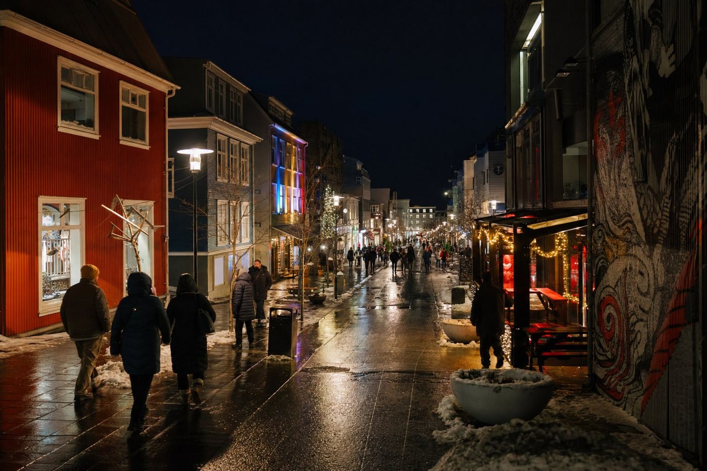 Kışlık montlarıyla gece Reykjavik merkezinde ıslak ve ışıklarla aydınlanmış bir alışveriş caddesinde yürüyen insanlar