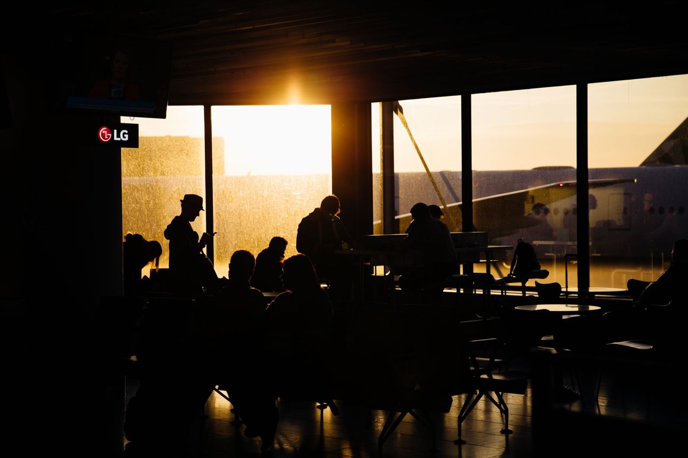 Passengers waiting with luggage inside Keflavik airport arrivals hall